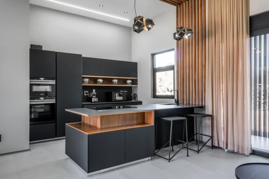 Elements of black, white, and wood were married to create perfect harmony in this kitchen. These elements were carried throughout the house to other areas to ensure a perfect flow.
