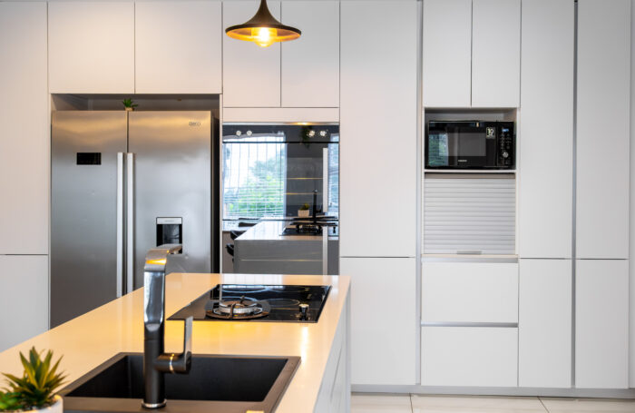 This contemporary kitchen design blends sleek minimalism with warm natural textures, creating a space that feels both stylish and inviting